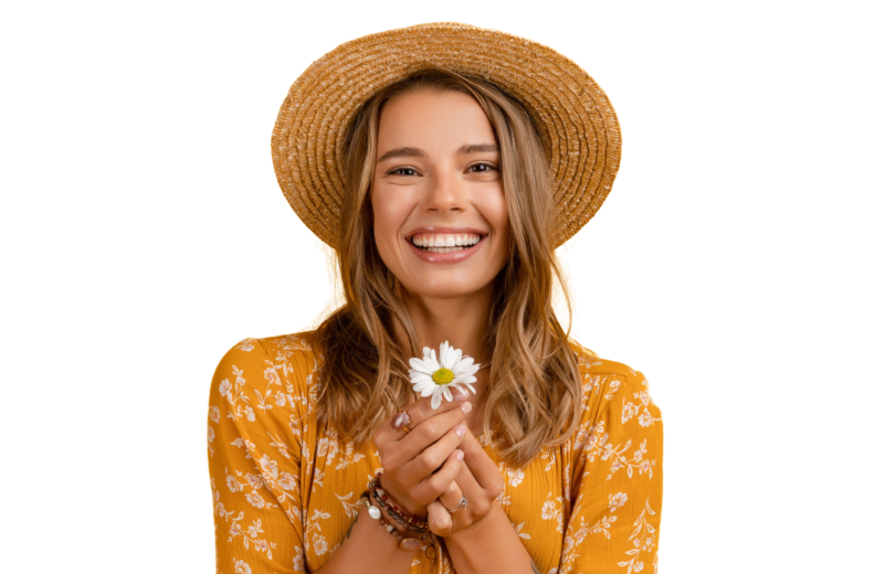 mujer joven sonriendo con vestido amarillo y sombrero de paja con flor de margarita en las manos