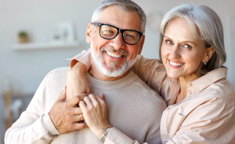 Primer plano de la hermosa pareja de mediana edad sonrientes marido y mujer mirando la cámara con ternura