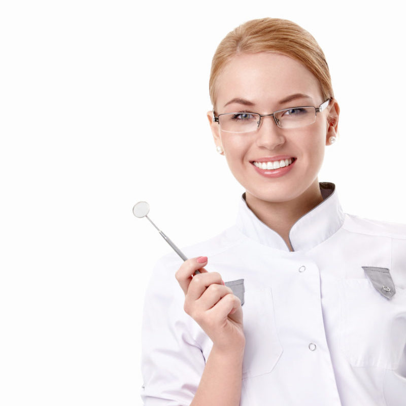 Una joven dentista con un espejo dental sobre un fondo blanco